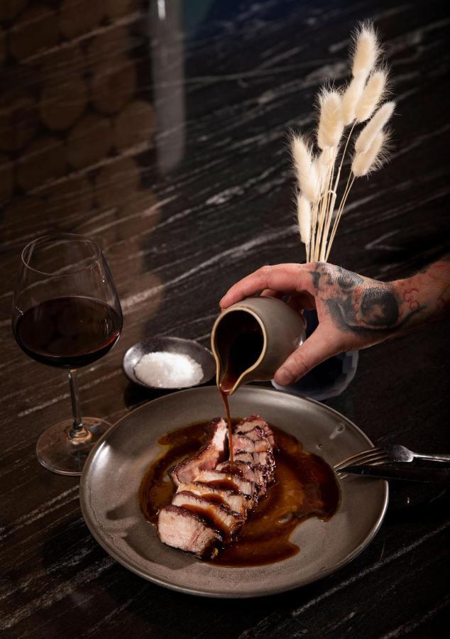 Qt Distretto di Queenstown Esterno foto A chef seasoning a dish